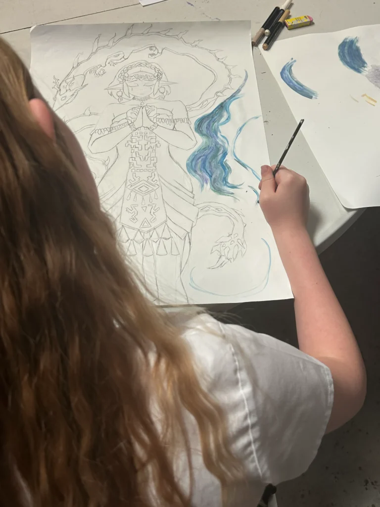 the back of a girl paining with blue paint