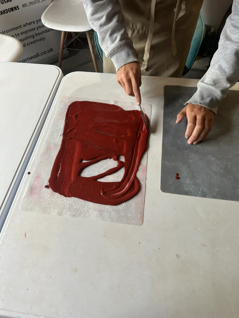 student cutting out red clay on the work table