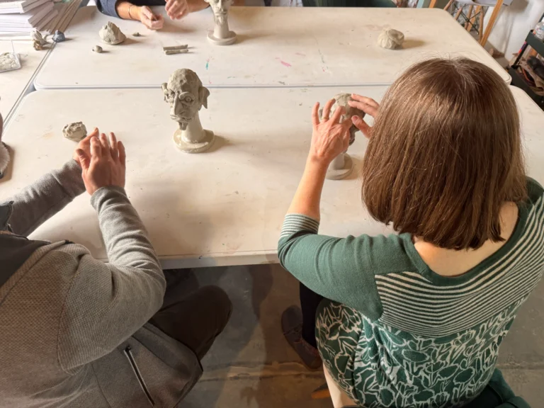 picture from behind where students work on their clay heads